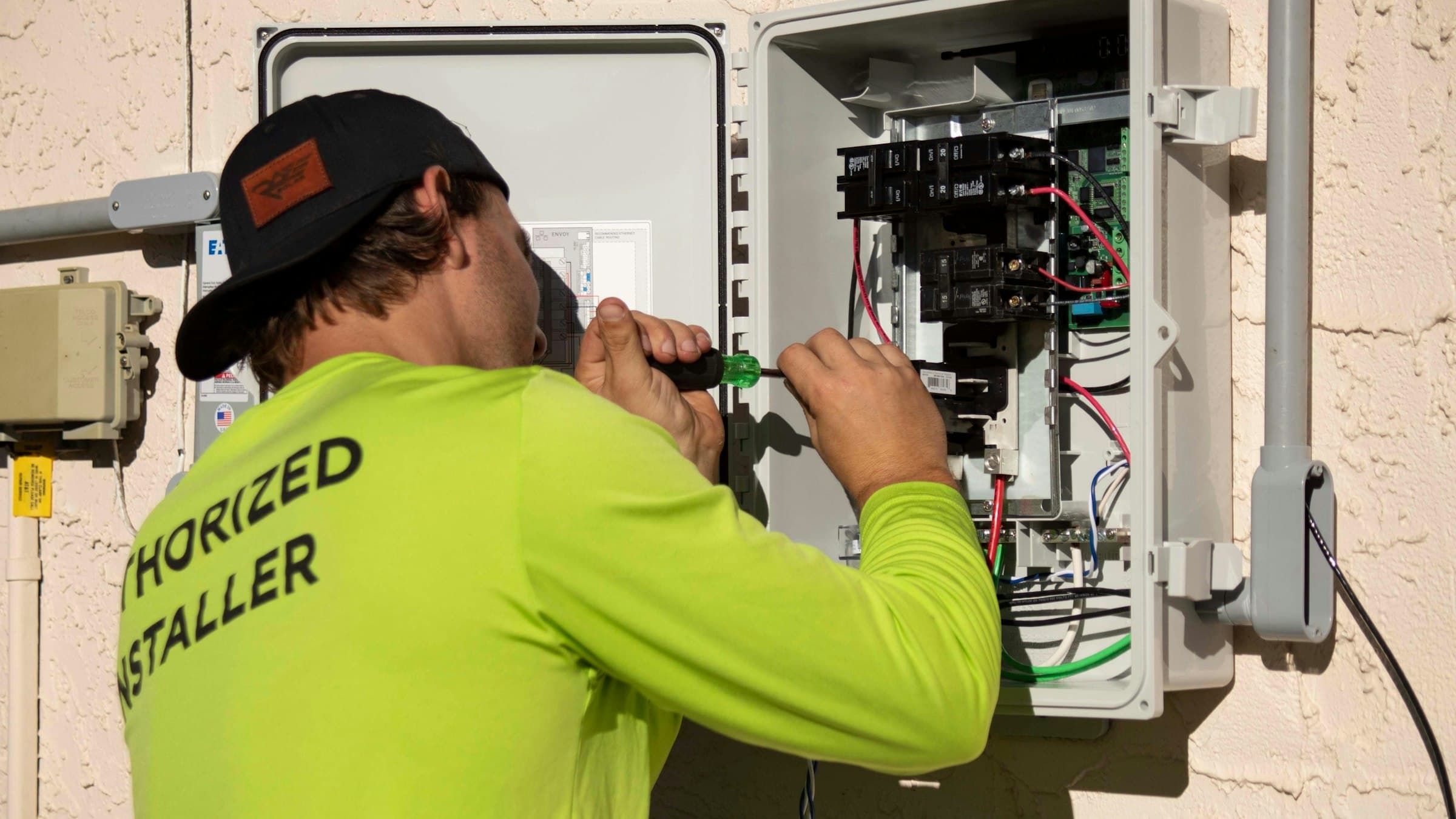 An electrician working on an electrical panel